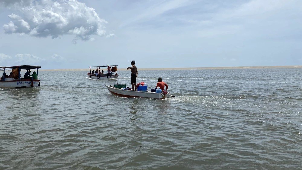 Imagem mostra pescadores em três barcos na Praia da Raposa, em São Luís. Região é alvo de exploração de petróleo, que pode afetar biodiversidade e sustento da população local