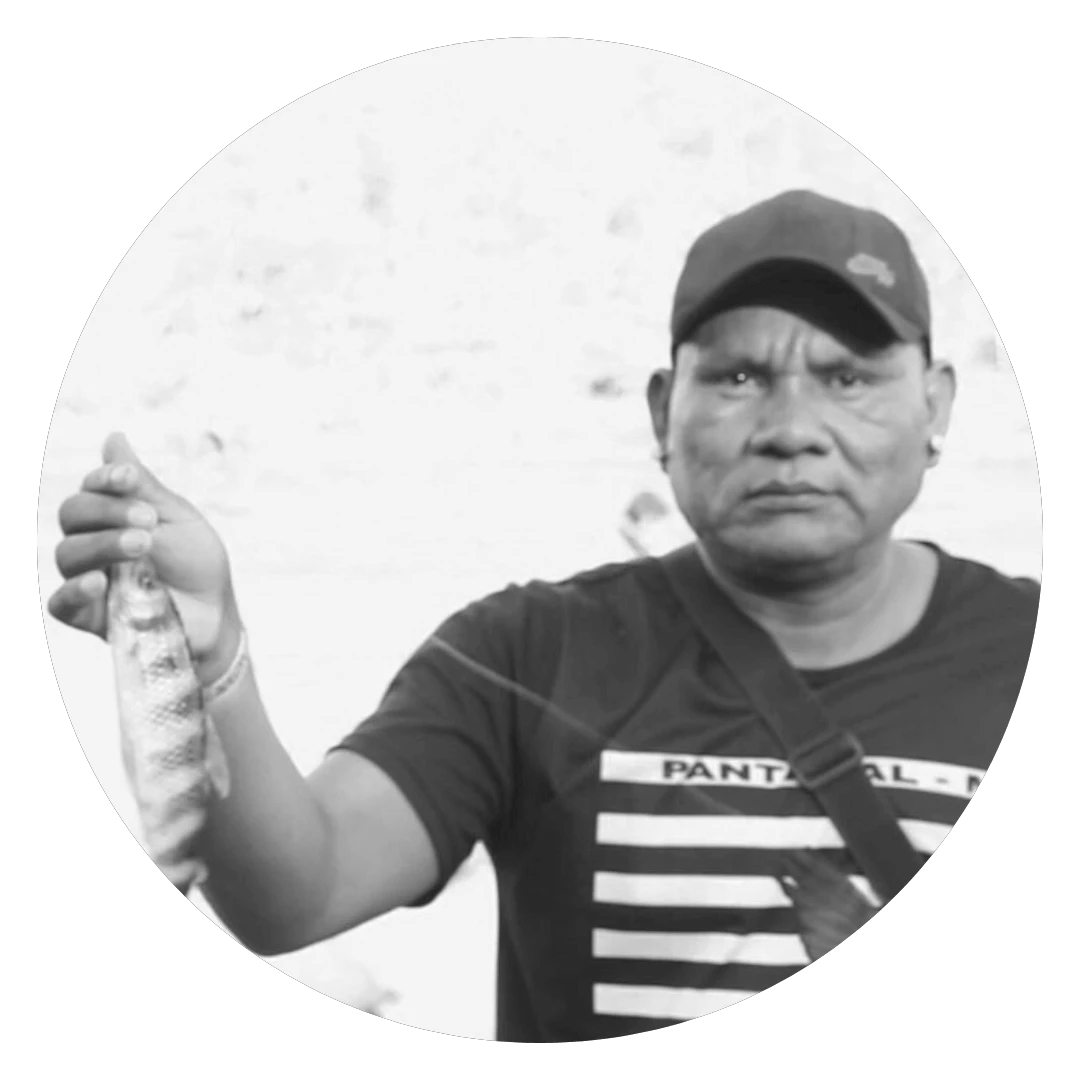 Róptsudi Rãiwari é um homem indígena, na imagem ele aparece usando boné e camiseta preta, ele segura um peixe recém-pescado
