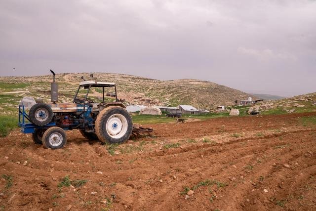 Pequeno veículo agrícola em frente às moradias de palestinos nas cavernas