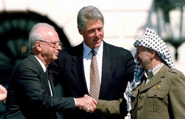 À esquerda o então líder palestino, Yasser Arafat, ao centro o então presidente dos Estados Unidos, Bill Clinton, e à direita o  então premiê israelense, Yitzahk Rabin