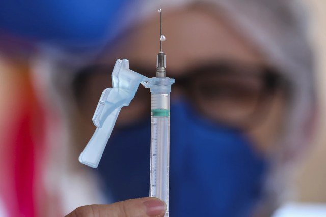 Enfermeira prepara seringa com vacina
